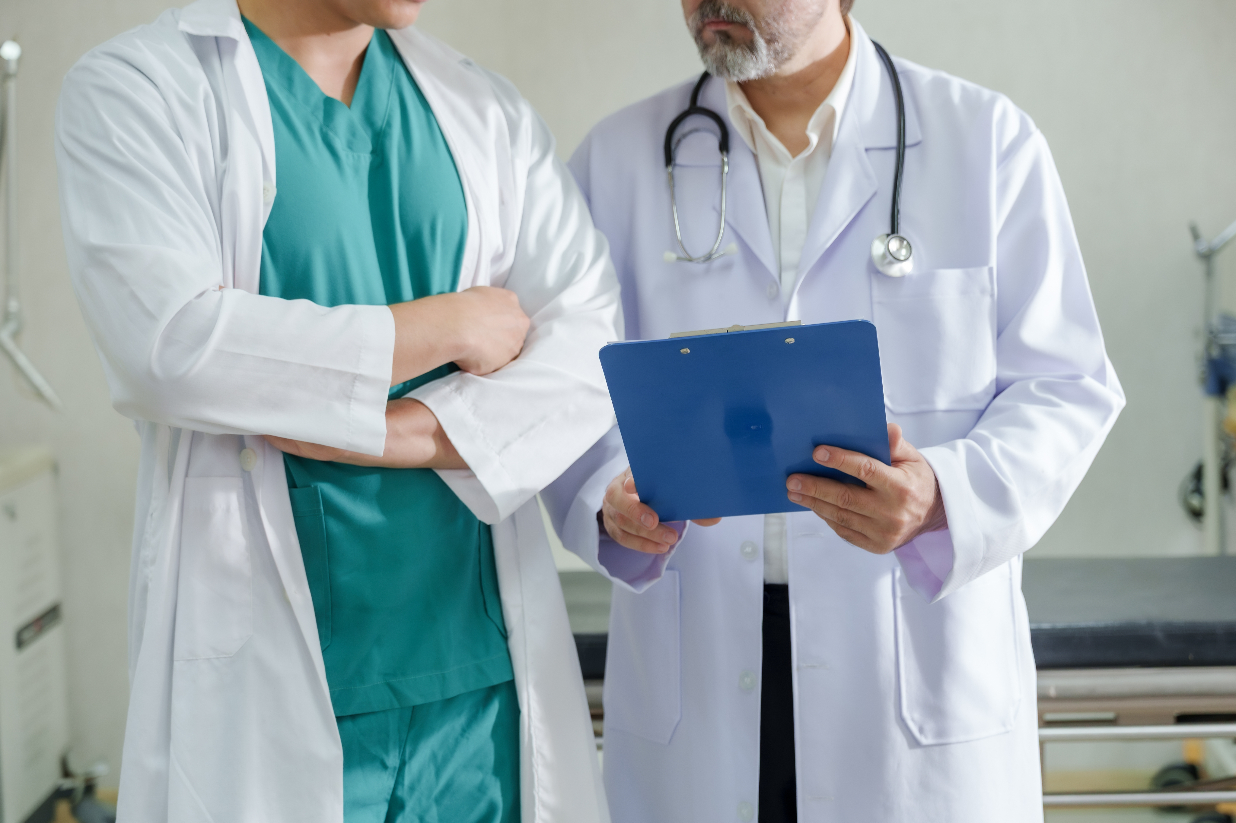 Two women sitting at a modern table talking with a city view behind them.